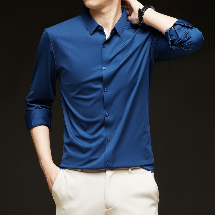 Camicia uomo blu elegante, maniche lunghe arrotolate, abbinata a pantaloni chiari. Moda maschile, abbigliamento casual chic.
