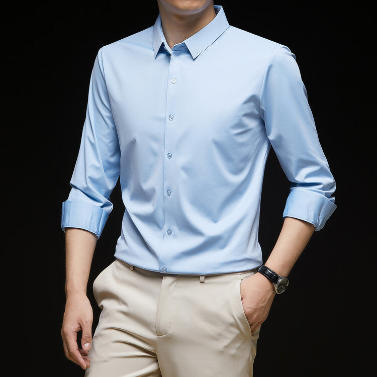 Camicia azzurra elegante da uomo con maniche lunghe arrotolate, abbinata a pantaloni beige. Stile formale, moda maschile, abbigliamento business casual.
