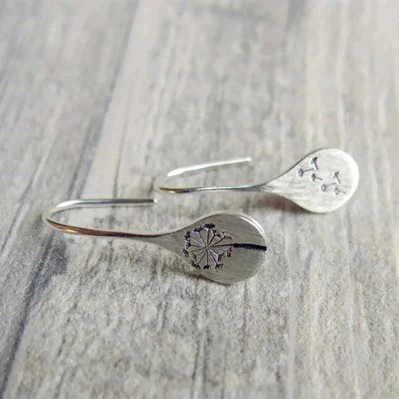Sterling silver dandelion teardrop dangle earrings with hook closure.