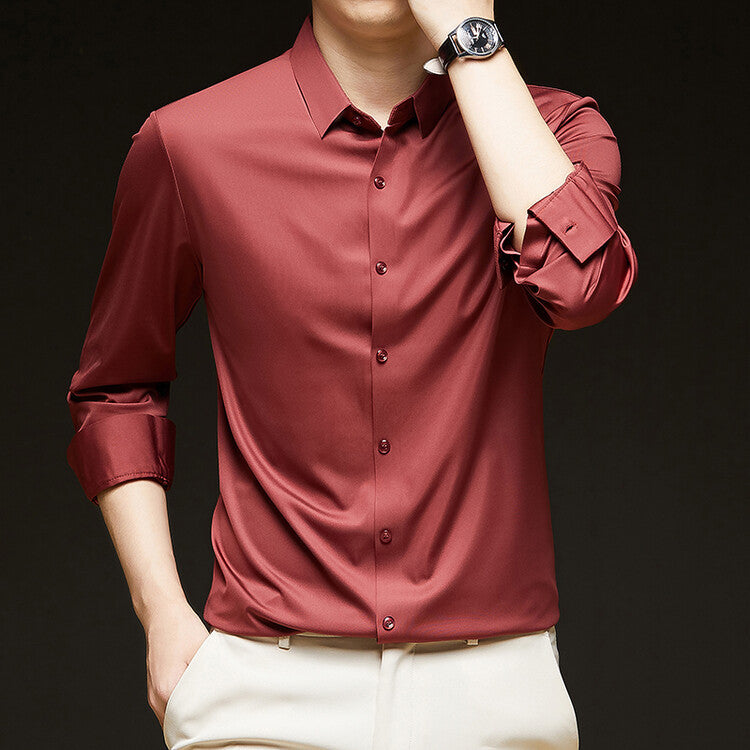 Camicia uomo elegante in seta rossa, maniche lunghe, abbinata a pantaloni chiari. Moda maschile, abbigliamento formale, stile sofisticato.