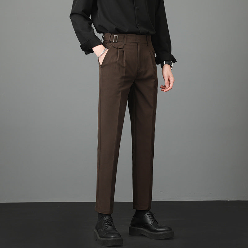Pantaloni eleganti marroni da uomo con cintura, abbinati a camicia nera e scarpe nere. Moda maschile, abbigliamento formale, stile moderno.