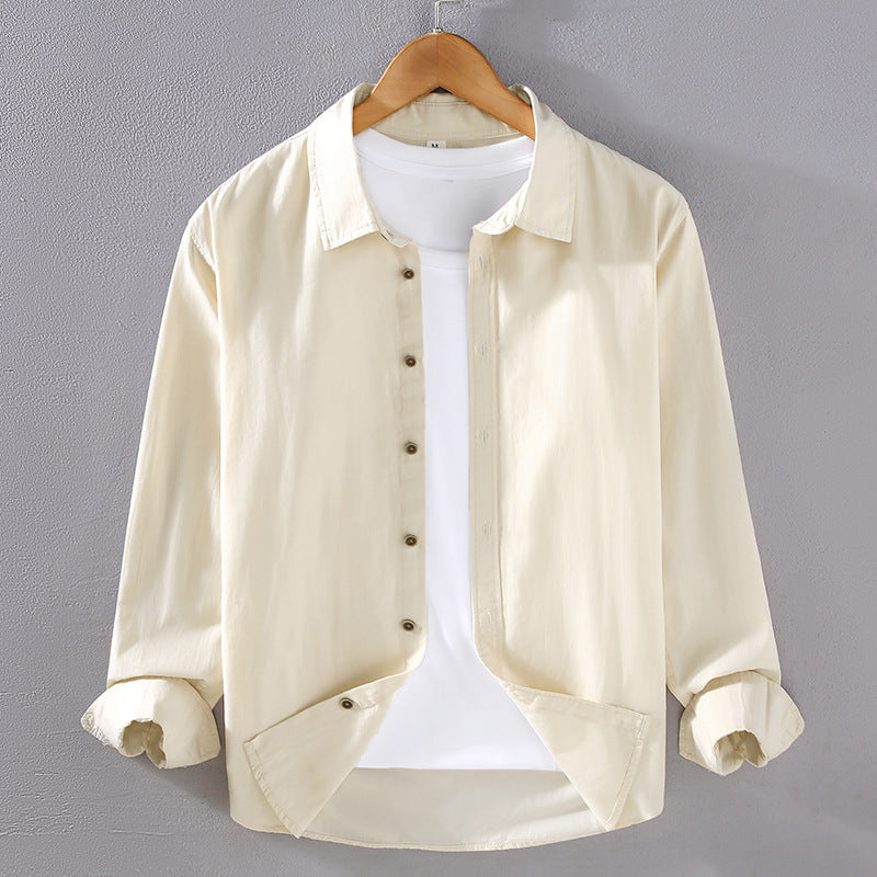 Camicia beige da uomo su gruccia, maniche lunghe, abbinata a t-shirt bianca. Moda casual, abbigliamento maschile elegante, sfondo grigio.