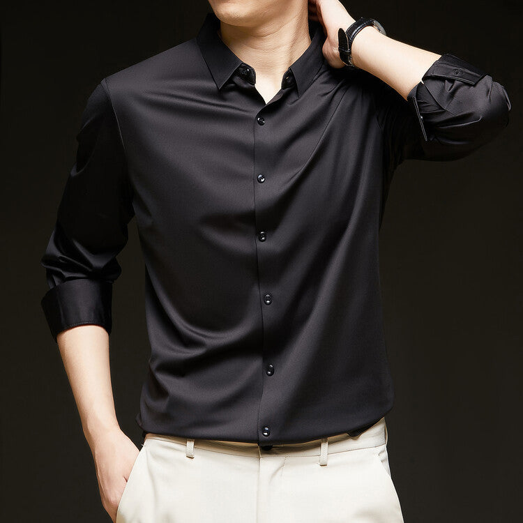 Camicia nera elegante da uomo con maniche lunghe, abbinata a pantaloni chiari. Moda maschile, abbigliamento formale, stile sofisticato.