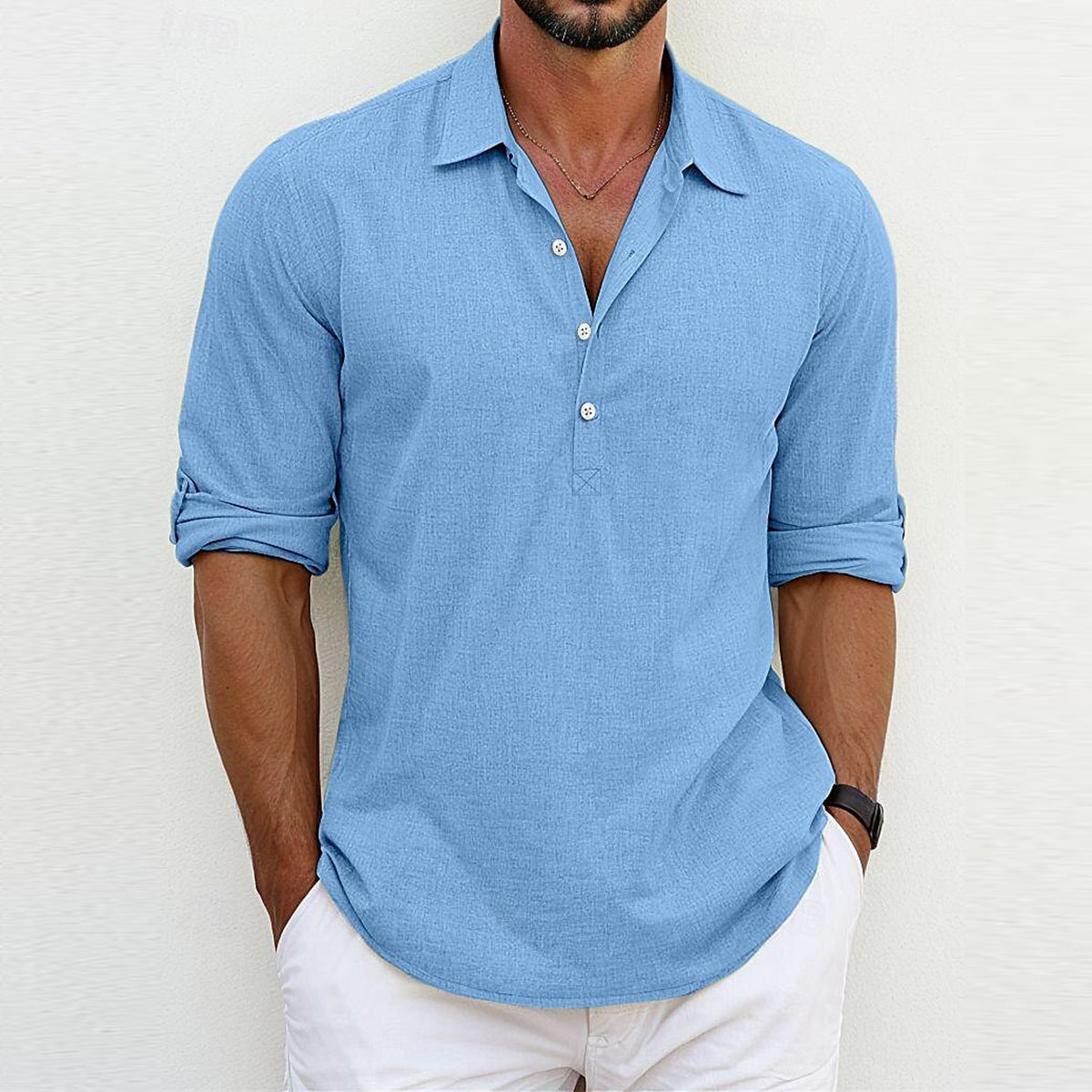 Camicia uomo azzurra a maniche lunghe, stile casual, con colletto aperto e bottoni, abbinata a pantaloni bianchi. Moda maschile estiva elegante.