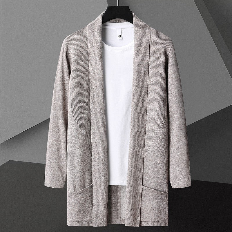 Cardigan grigio chiaro in maglia su gruccia, con tasche frontali, abbinato a t-shirt bianca. Moda uomo, abbigliamento casual elegante.