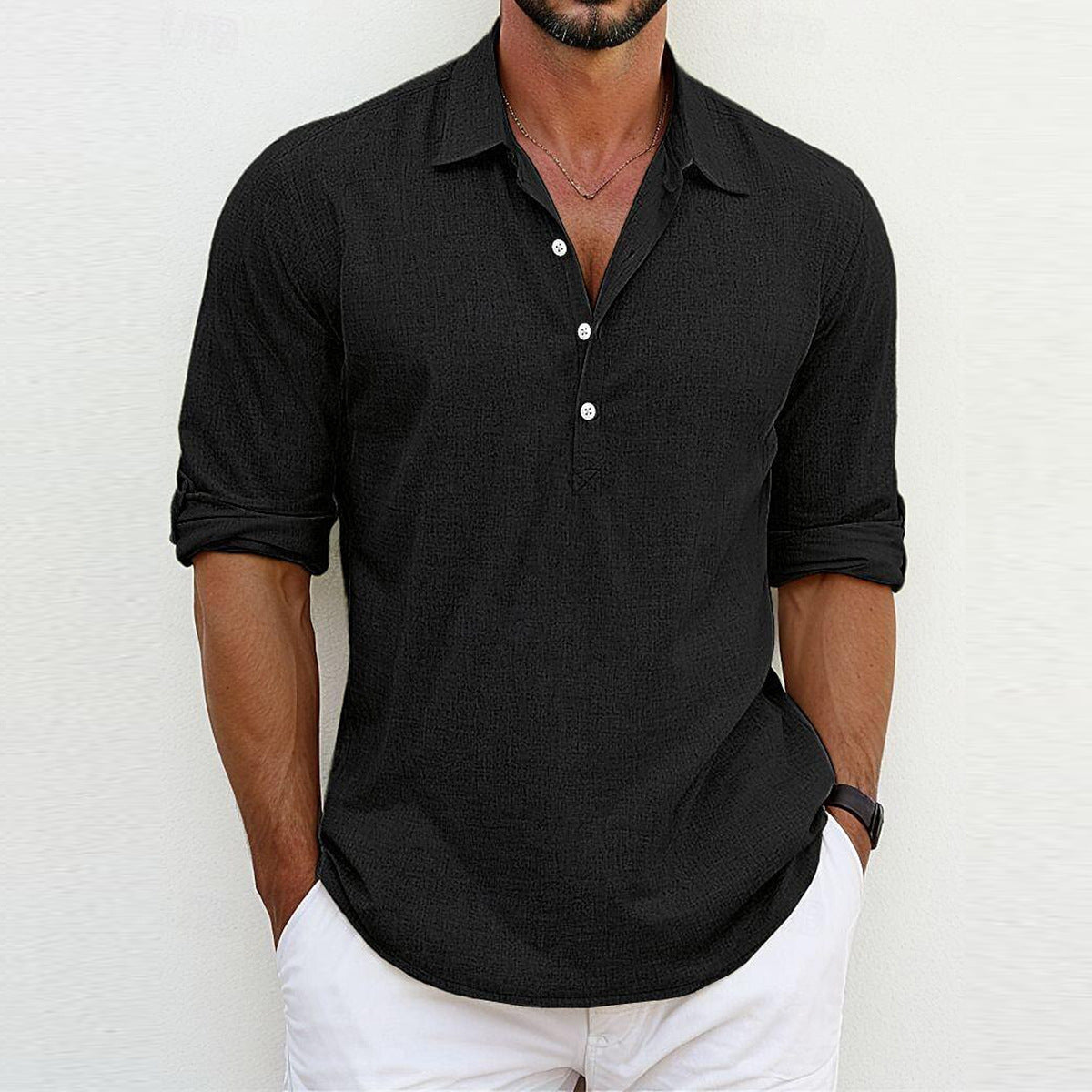 Camicia nera da uomo a maniche lunghe, stile casual, con colletto aperto e bottoni, abbinata a pantaloni bianchi. Moda maschile elegante.
