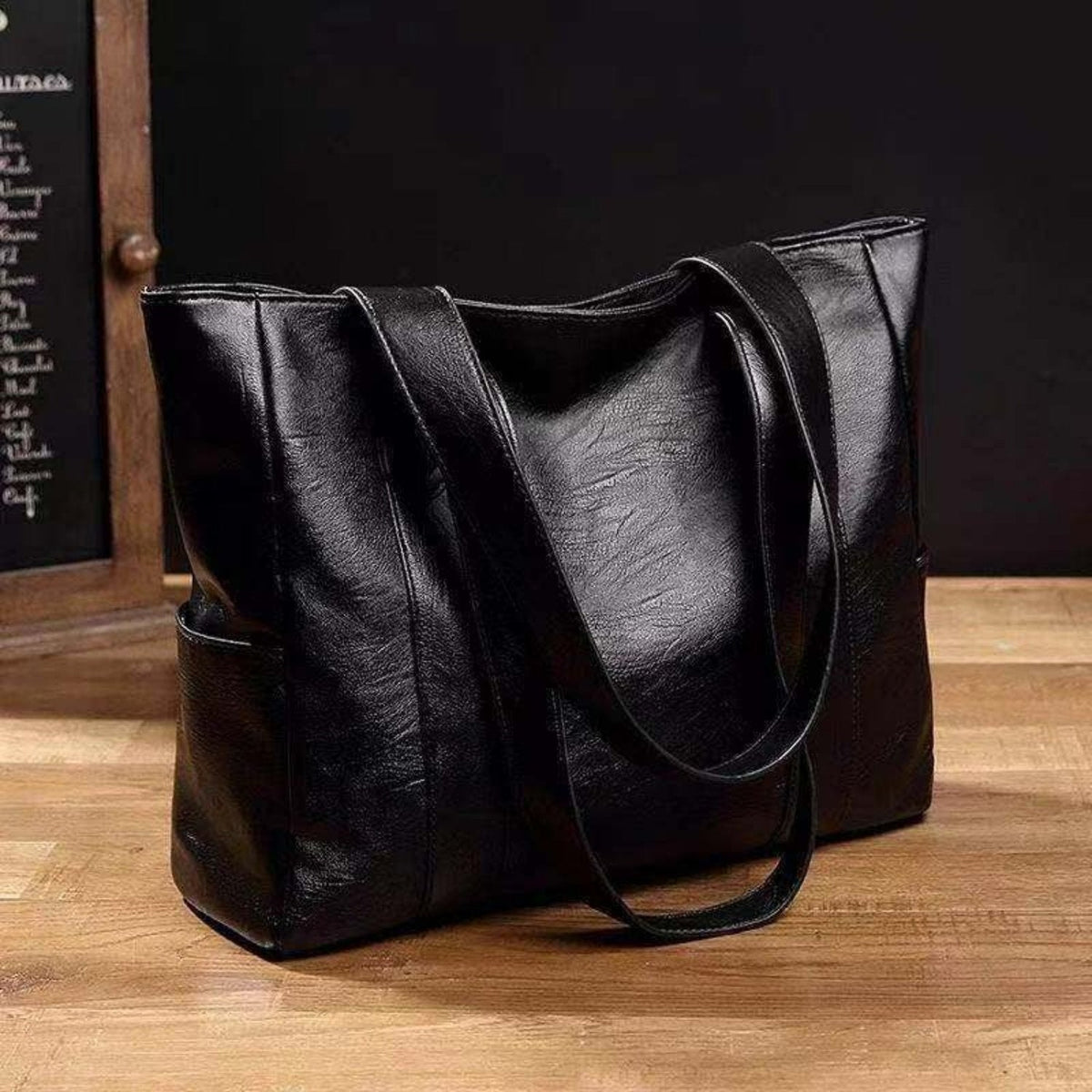 Women's leather tote bag with spacious side pockets, durable leather craftsmanship, elegant design for work or travel.